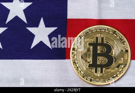 Gros plan sur la pièce de monnaie en bitcoin d'or sur le drapeau des états-unis Banque D'Images