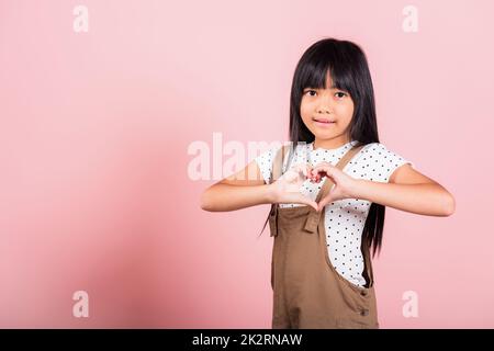 Petit enfant asiatique de 10 ans montrant un cœur Banque D'Images