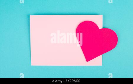 Enveloppe rose avec un coeur, espace de copie vide, fond bleu, carte de vœux de Saint-Valentin, courrier romantique, lettre d'amour Banque D'Images