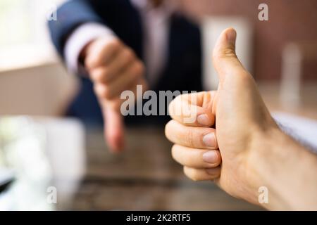 Deux gens d'affaires montrant le signe des Thumbs Up et Thumbs Down Banque D'Images