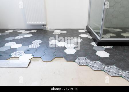 Amélioration de la maison, différents types de carreaux sur le sol dans une salle de bains Banque D'Images