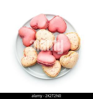 Macarons Sweet en forme de cœur sur une plaque isolée sur fond blanc. Banque D'Images