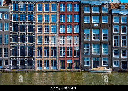 Maisons et bateau sur un canal à Amsterdam Damrak avec réflexion. Ams Banque D'Images