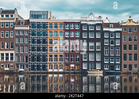 Maisons et bateau sur un canal à Amsterdam Damrak avec réflexion. Ams Banque D'Images