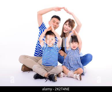 Bonne famille formant le toit de la maison avec les mains à la maison. Concept d'assurance Banque D'Images