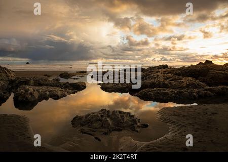 WA22047-00...WASHINGTON - nuages se reflétant dans une piscine à marée au coucher du soleil à Ruby Beach sur la côte Pacifique dans le parc national olympique. Banque D'Images
