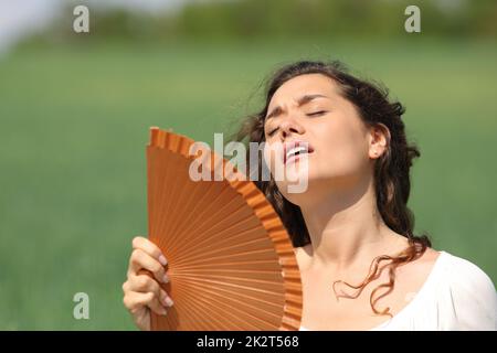 Femme stressée souffrant d'un coup de chaleur dans un champ Banque D'Images