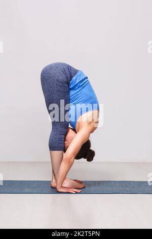 Woman doing yoga asana - Uttanasana flexion avant permanent Banque D'Images