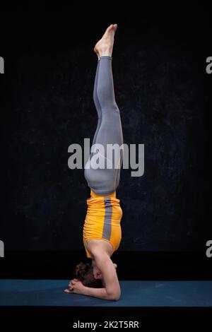 Yoga - woman doing yoga asana sirsana Banque D'Images