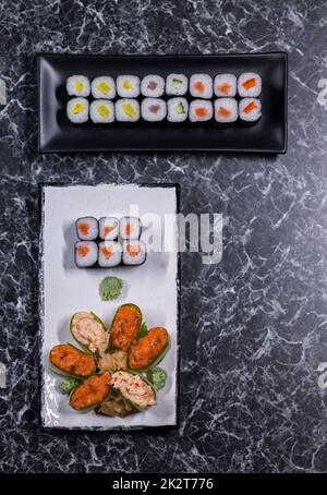 ensemble de petits pains à sushis aux fruits de mer sur une pierre noire arrière-plan Banque D'Images