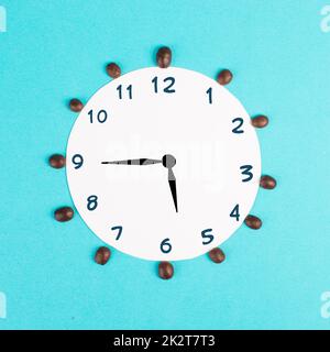 Réveil avec chiffres et grains de café, réveil le matin, ayant une date limite, heure pour une pause, concept minimaliste, fond bleu Banque D'Images