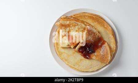 Crêpes françaises pour le petit déjeuner avec confiture de fraises. Pancakes ou crêpes de levure de blé doré dans une assiette blanche. Banque D'Images