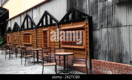 Les tables et les chaises devant les fenêtres en bois dans un café. Banque D'Images