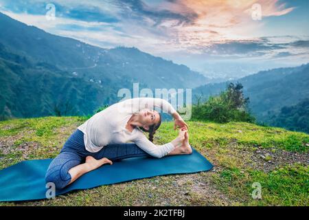 Young fit woman faisant le Hatha Yoga asana dans les montagnes Banque D'Images