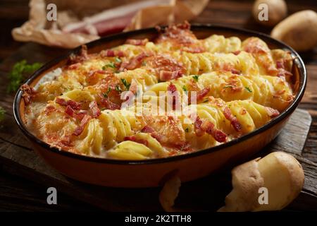 Délicieux gratin crémeux avec pommes de terre et jambon servi sur table dans la cuisine Banque D'Images