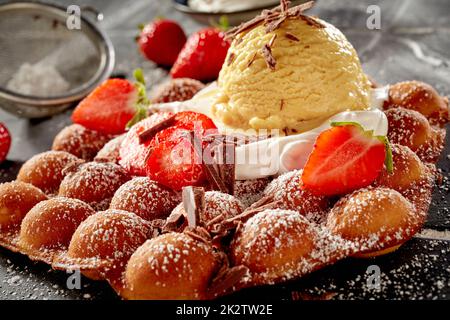 Gaufre à bulles recouverte de crème fraîche aux fraises et de glace Banque D'Images