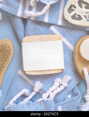 Porte-savon fait main sur serviette de bain bleue vue de dessus, maquette d'emballage. Produits de beauté naturels Banque D'Images