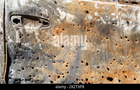 Carrosserie brûlée criblée de balles. La guerre de la Russie contre l'Ukraine. Tiré par la voiture militaire russe de civils pendant l'évacuation. Traces de balles et fragments de coquilles. Banque D'Images