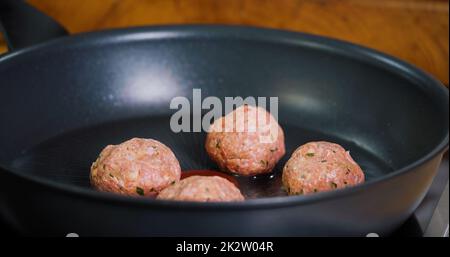 Gros plan faites frire des boulettes de viande sur une poêle chaude Banque D'Images