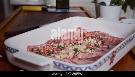 Viande d'agneau assaisonnée d'épices, d'ail, d'herbes avant cuisson. Agneau cru juteux Banque D'Images