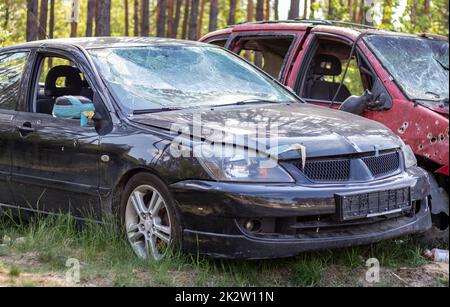 Beaucoup de voitures cassées après un accident de la circulation dans le parking d'une station de restauration sur la rue. Carrosserie de la voiture endommagée à l'extérieur de l'atelier. Vente de véhicules d'urgence d'assurance aux enchères. Banque D'Images