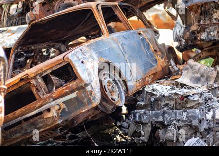 Voitures après l'incendie. Repassez les pièces d'une voiture brûlée. Voitures brûlées abandonnées sur le côté d'une campagne tranquille. Explosion, le résultat d'un incendie. Concept d'assurance automobile. Guerre de la Russie contre l'Ukraine. Banque D'Images