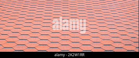 Nouveau toit avec bardeaux rouges. Carreaux sur le toit de la maison. À utiliser pour annoncer la fabrication et l'entretien du toit. Texture à pois. Toiture abordable. Bannière avec espace de copie. Banque D'Images