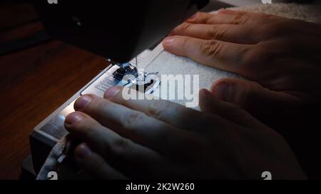 Aiguille de la machine à coudre en mouvement. L'aiguille se déplace rapidement vers le bas. Le tailleur rade la serviette. Banque D'Images