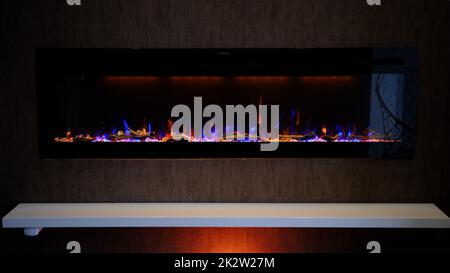 vue sur cheminée électrique avec flamme artificielle étincelante, décor intérieur, flamme orange et bleue Banque D'Images