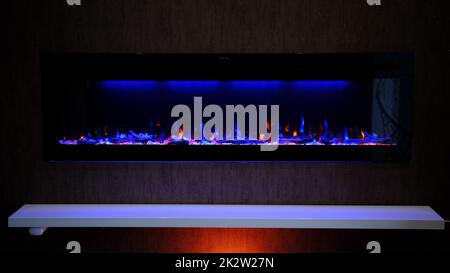 vue sur cheminée électrique avec flamme artificielle étincelante, décor intérieur, flamme orange et bleue Banque D'Images