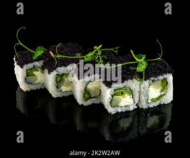 Mettre en place le rouleau de sushi. Cuisine japonaise traditionnelle. Isolé sur fond noir Banque D'Images