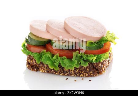 Sandwich avec des tranches de saucisse et de légumes isolées sur un fond blanc. Banque D'Images