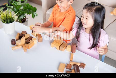 Enfants garçon et fille jouant avec constructeur en bois bloc bâtiment Banque D'Images