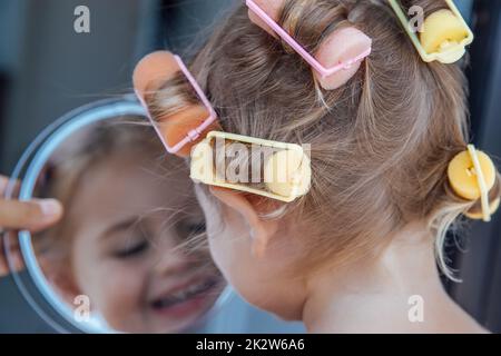 Bébé mignon dans les curlers Banque D'Images