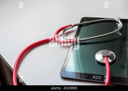 Le stéthoscope rouge sur tablette noire affiche les dossiers de santé et les dossiers médicaux numériques sur la sécurité des données dans le cloud pour les médecins numériques et le diagnostic de récupération numérique grâce à des équipements et technologies modernes Banque D'Images