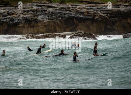 Un groupe de surfeurs en file d'attente pour les vagues suivantes à Malabar Beach en Australie Banque D'Images