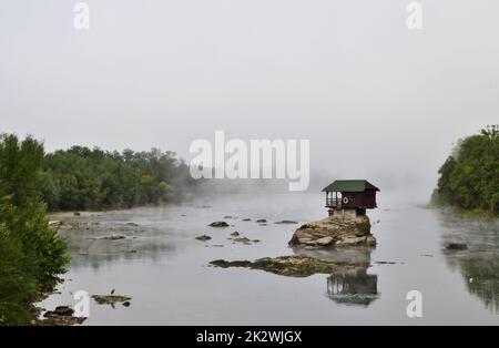 Maison emblématique sur la Drina entre la Serbie et la Bosnie-Herzégovine un matin brumeux Banque D'Images