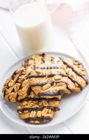 Biscuits aux pépites avec des arachides et des bandes de chocolat sur la table blanche. Banque D'Images