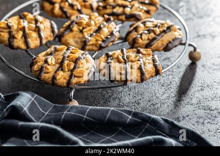 Biscuits aux pépites avec des arachides et des bandes de chocolat sur table noire. Banque D'Images