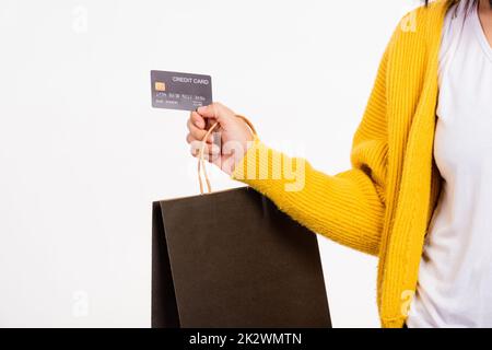 femme main elle porte une chemise jaune tenant des sacs de shopping noirs et carte de crédit Banque D'Images