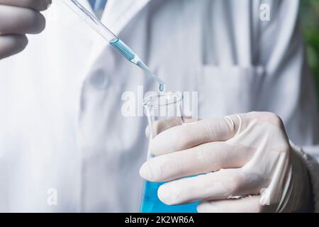 Chercheur avec tubes à essai chimiques de laboratoire en verre avec liquide pour le concept de recherche analytique, médicale, pharmaceutique et scientifique. Banque D'Images