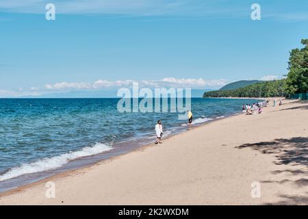 Baie Barguzinsky du lac Baikal, Buryatia, Russie. Les personnes se reposant sur une plage de sable en été ensoleillé. Banque D'Images