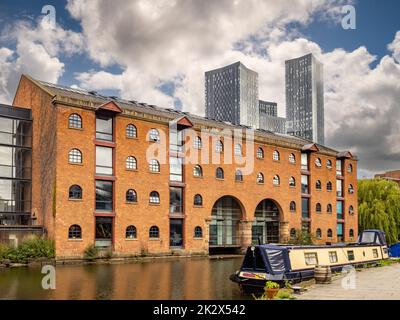 Le canal de Bridgewater le long de Merchants Warehouse, avec les quatre tours de la place Deansgate au loin. Banque D'Images