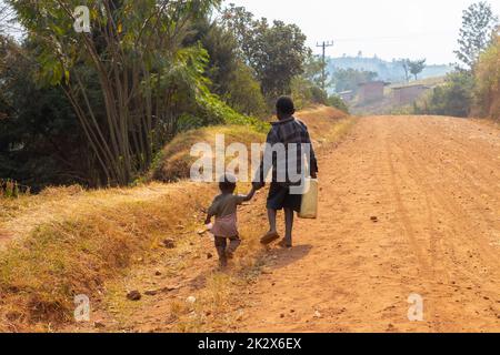 Des enfants de différents âges essayaient de recueillir de l'eau potable en Ouganda Banque D'Images