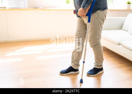 Homme marchant avec des béquilles Banque D'Images