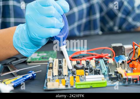 Le technicien utilise la boule de soufflerie d'air pour nettoyer la poussière de l'ordinateur de la carte de circuit imprimé. Réparer la technologie de mise à niveau et de maintenance. Banque D'Images