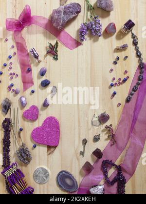 Bijoux violet et rose avec coeurs à paillettes et pierres améthystes sur fond en bois Banque D'Images