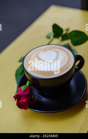 Cappuccino avec latte art et une rose rouge Banque D'Images