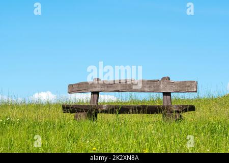 Vider le banc dans un champ d'herbe vert naturel non taillé Banque D'Images