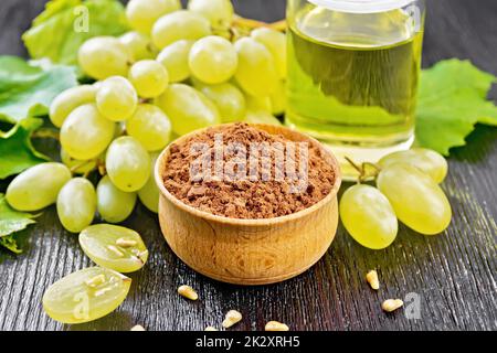 Farine de pépins de raisin dans un bol sur carton foncé Banque D'Images